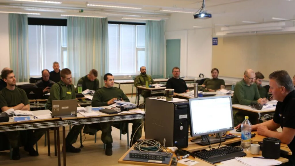 Deltagare vid en utbildning med datorer och dokument